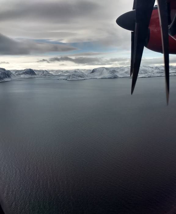 Photo prise du hublot d’un aéronef durant une patrouille d’affirmation de la souveraineté qui montre surtout les eaux de la Frobisher Bay, au Nunavut, ainsi qu’une partie des côtes. 