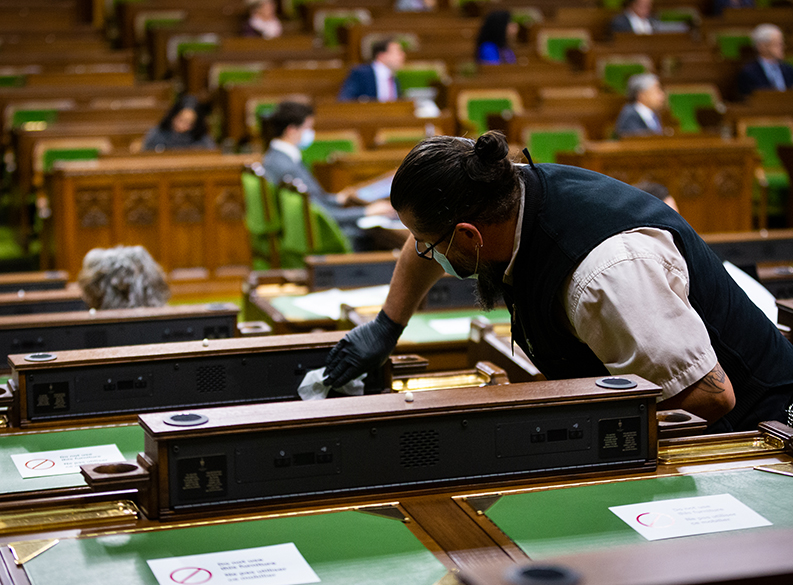 Photo d’un employé nettoyant le bureau d’un député dans la Chambre des communes
