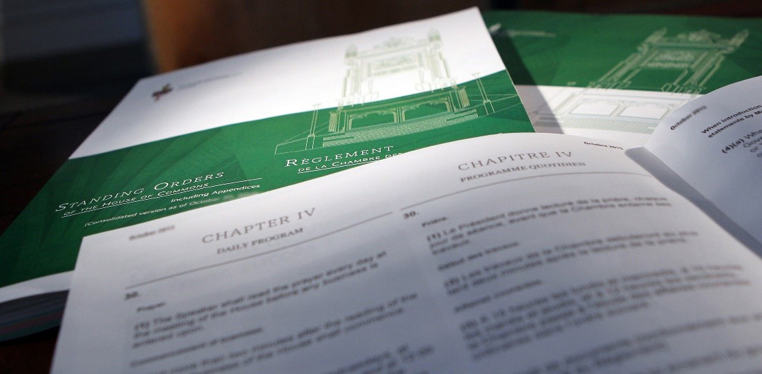 Three printed copies of the Standing Orders of the House of Commons. In the foreground, a document is open to reveal two pages of the text.